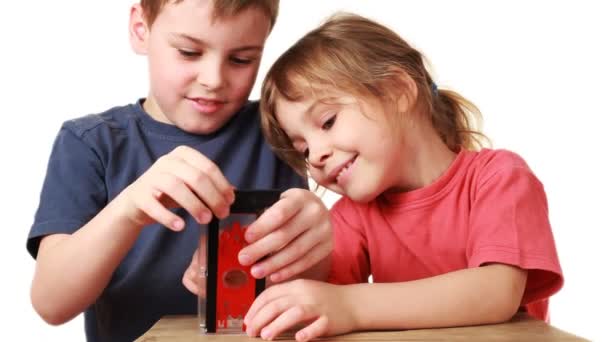 Boy shows sister focus with toy guillotine for finger — Stock Video