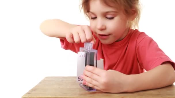 Little girl shows focus transforming paper into euros — Stock Video