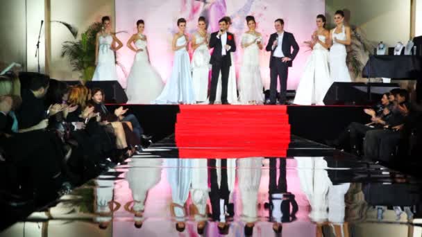 Modelos en vestidos de novia blancos con el principal stand show en el escenario — Vídeo de stock