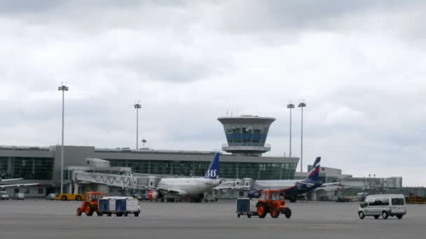 Two planes SAS and AEROFLOT stand in front of control tower — Stock Video