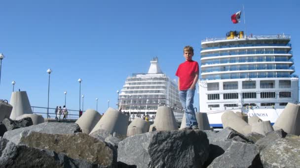 男孩玩耍的前面邮轮，驻扎在湾 — 图库视频影像