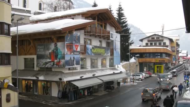 Auto's gaan in de buurt van shop van ski uitrusting moreboards die op de hoek van de straat staat — Stockvideo
