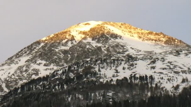 Pico de montaña en el que se encuentra la cima cruz es brillado por el sol — Vídeos de Stock