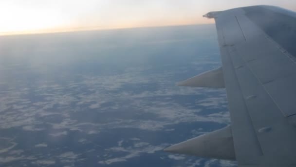 From window of flying plane is visible sunset and Earth — Stok video