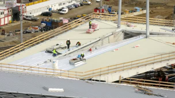 Workers lay an insulating cover on roof — Stock Video