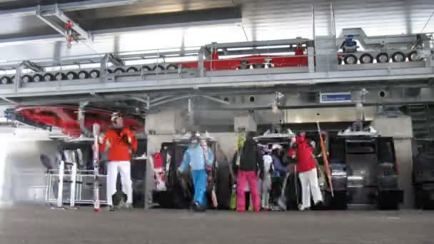 Many tourists of skiers leave rope-way cabins skyrail on station on mountain — Stock Video