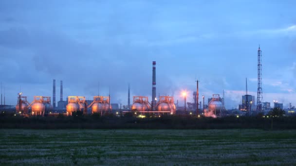Фосфорный завод в свете фонарей стоит на фоне вечернего неба — стоковое видео