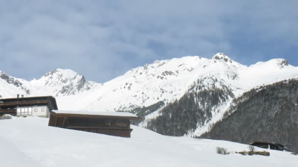站在山对山的斜坡上有小屋和覆盖着皑皑白雪 — 图库视频影像