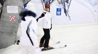 Onlar birlikte kapalı Kayak hill devam et ve kayakçı eğitmen kız yardımcı olur.