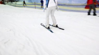 yamaçta kayak için beyaz elbiseli kız iner