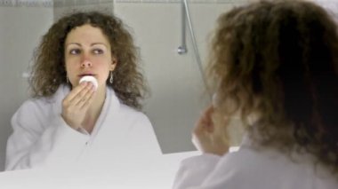 beyaz bornoz giyen kadın gözümün önünde banyo aynada temizler