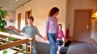 Koridor boyunca yürüyüş iki çocuk ile anne