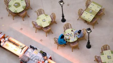 Two women sit at table near buffet in café