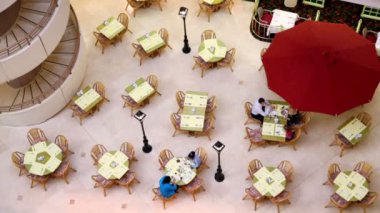 Several people sit at tables on café