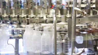 küçük deterjan ile dolu şişeler bir sürü büyük süt fabrikasında döndürülmüş