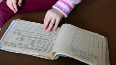 Little girl turns over pages of medical chart