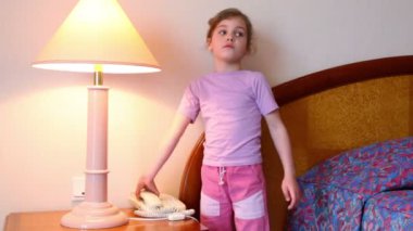 küçük kız ayağa ve lamba yakın yatak odasında telefon konuşmak