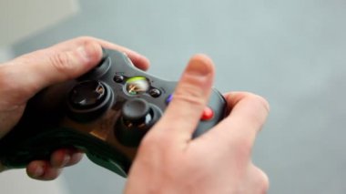 adam renkli gamepad ile elinde oynar.