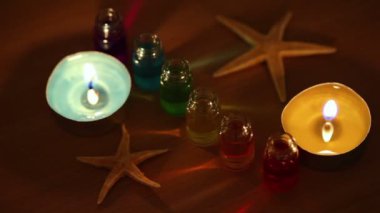 iki mum yakmak, altı açık şişe renk aroma yağı ve deniz yıldızı ile yatıyordu.