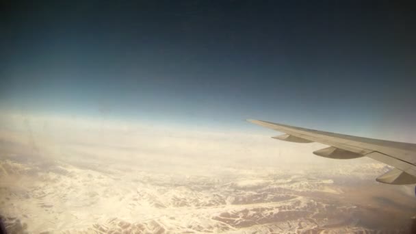 Flugzeug fliegt über Berge, die vom Fenster aus sichtbar sind — Stockvideo