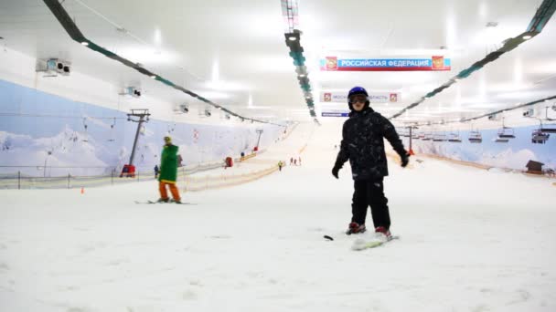 Skiër jongen proberen vast te houden evenwicht in ski resort vier seizoenen snejcom — Stockvideo