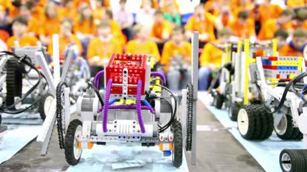 Robots de juguete de pie en la mesa en el fondo de muchos niños — Vídeo de stock