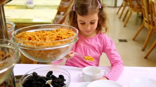 Niña toma cereal y lo pone en el plato en la cafetería — Vídeos de Stock
