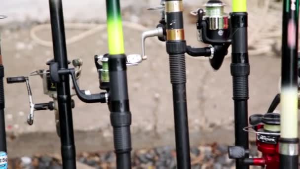 Lot of fishing rods stand near wall — Stock Video