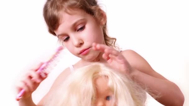 Kleines Mädchen kämmt Puppenhaare — Stockvideo