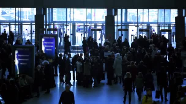 Viele Menschen laufen in Bahnhofsnähe mit Glaswänden herum — Stockvideo