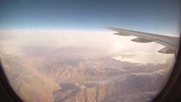 Mountains are visible from window of flying plane — Stock Video