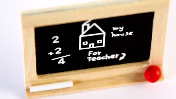 Pizarra de juguete rodeada de dibujo, inscripción y cálculo — Vídeo de stock