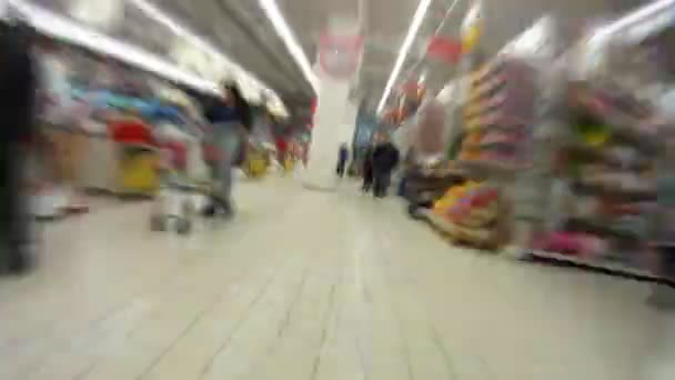 As pessoas caminham e estão envolvidas em compras no centro comercial — Vídeo de Stock