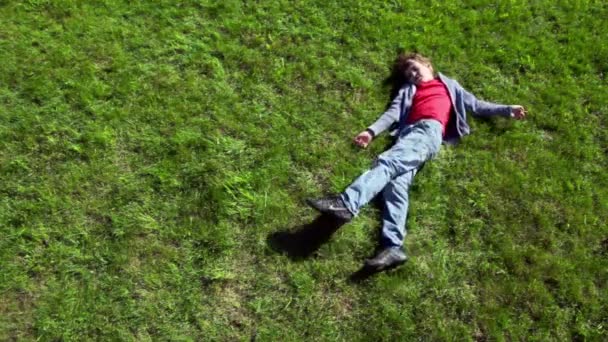 Kleine jongen lag op gras plot en vervolgens rolt weg — Stockvideo