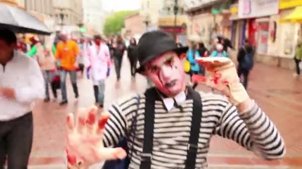 Bloody zombie mime walk by street among people during Zombie Parade — Stock Video