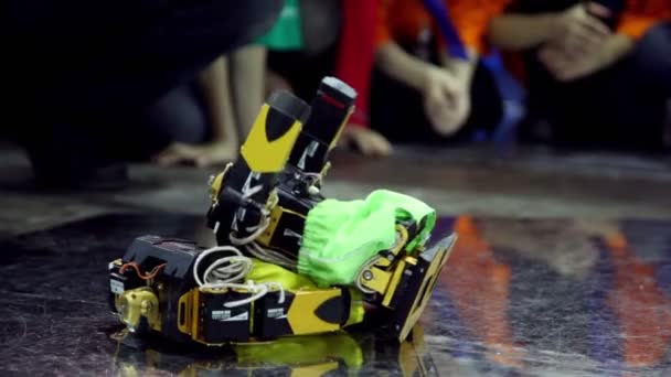 Dois robôs de brinquedo em shorts se deitam, caem e se levantam — Vídeo de Stock
