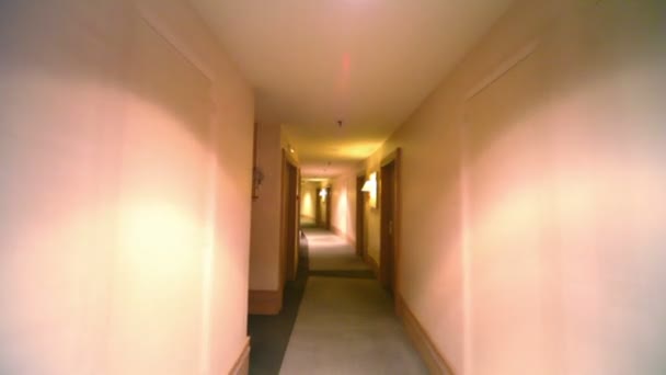 Linternas en la pared cerca de la puerta en pasillo oscuro en el hotel — Vídeo de stock