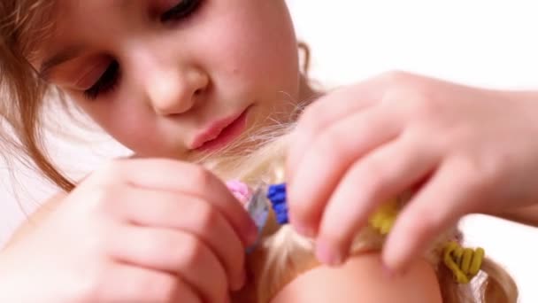 Little girl decorate dolls hairdo with bijouterie crystal — Stock Video