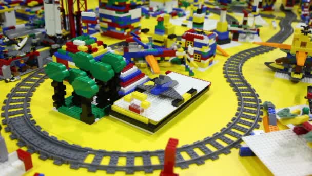 Tren de juguete se mueve por ferrocarril entre diferentes objetos — Vídeos de Stock