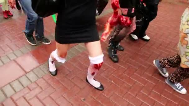 Girls zombies walk by pavement with bandage on legs and carry bloody baby — Stock Video