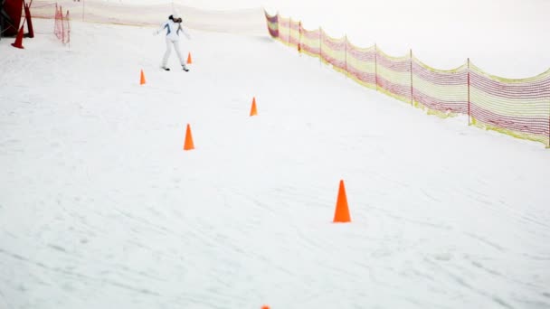 经验不足的女孩在滑雪板上下山山 perambulate 壁垒 — 图库视频影像