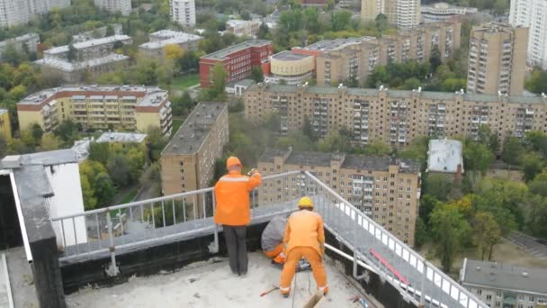 Lavoratori montano protezione sul nuovo tetto dell'edificio sul complesso residenziale Isola di Lussino — Video Stock