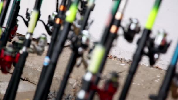 Balıkçılık çubuklar stand duvarının yakınında bir sürü — Stok video