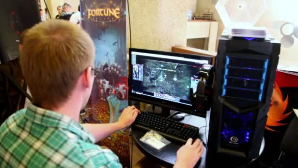 Ragazzo sedersi e giocare al videogioco per PC, vista da dietro durante Game Developers Conference 2011 — Video Stock