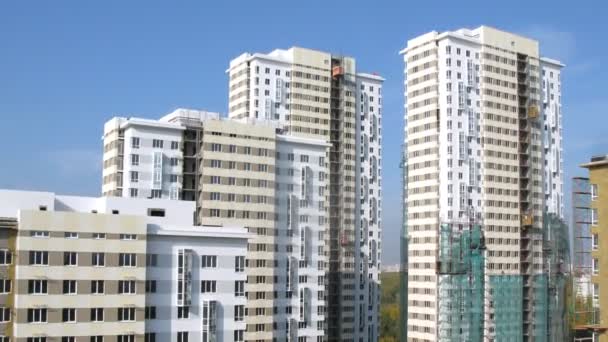 Mnoho nových budov s Stavební výtahy stojí pod modrou oblohou — Stock video