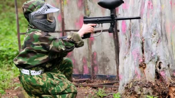 Çocuk paintball oyuncu topu pusu ağacının yakınında bulunan oturur. — Stok video