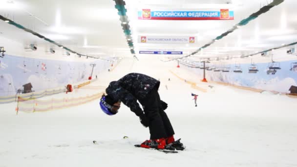 Malý lyžař chlapec drží rovnováhu a dělá nějaké cvičení na vrcholu kopce v centru sportu — Stock video