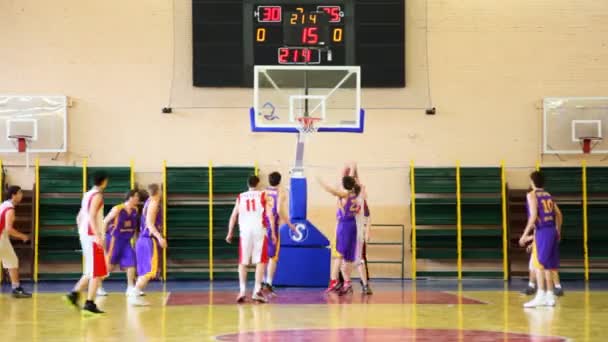 Гравець в сутичка кидає м'яч в кошик у матчі студент — стокове відео