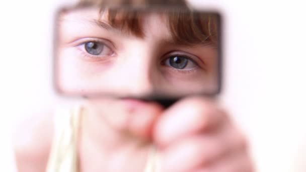 Little boy moves loupe in front of his face and enlarge it — Stock Video