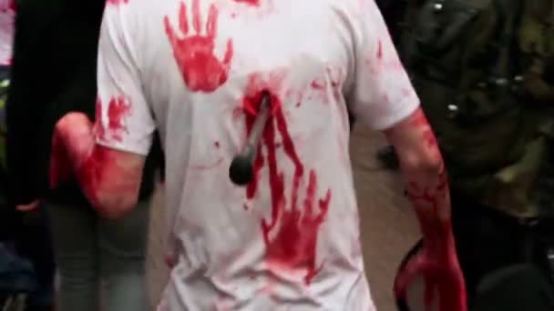 Человек с топором в спине ходит среди зомби — стоковое видео